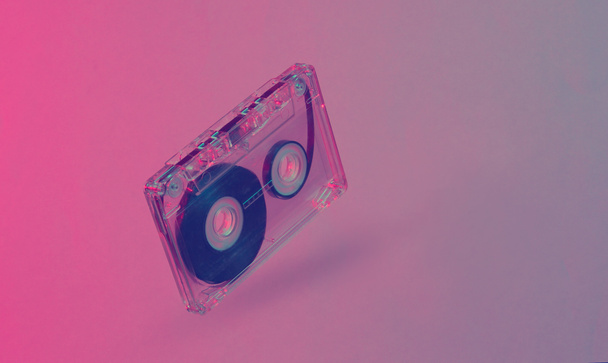 Minimalism retro style concept. 80s. Audio cassette in neon red blue light. Retro wave - Photo, Image