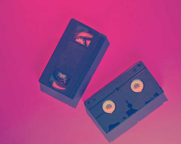 Estilo de onda retro dos casetes de vídeo con luz rosa-azul neón. 80. Vista superior - Foto, Imagen