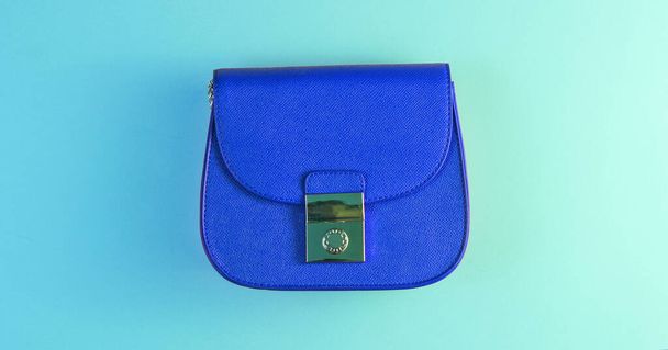 Conceito de moda minimalismo. Mini saco azul com luz de cor holográfica azul gradiente verde. Vista superior - Foto, Imagem