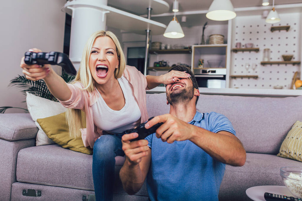 Beautiful young couple playing video games at home. - Photo, image