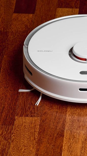 Smart Robot Vacuum Cleaner Xiaomi roborock s5 max on wood floor. Robot vacuum cleaner performs automatic cleaning of the apartment. 04.12.2020, Rostov region, Russia - Photo, image