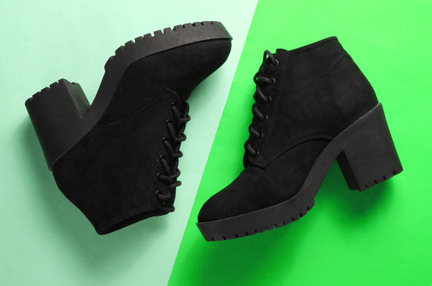 Black suede boots on a two-ton green background. Top view - Photo, Image