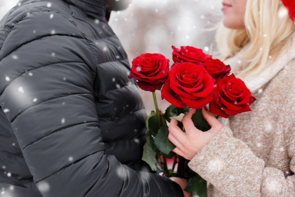 Jovem bonito cara dando uma menina um buquê de rosas no dia dos namorados - Foto, Imagem