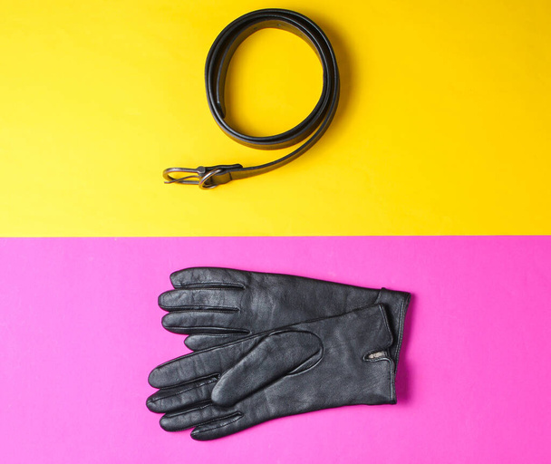 Minimalisme collage van modieuze accessoires op gekleurde achtergrond. Leren handschoenen, riem. Bovenaanzicht - Foto, afbeelding