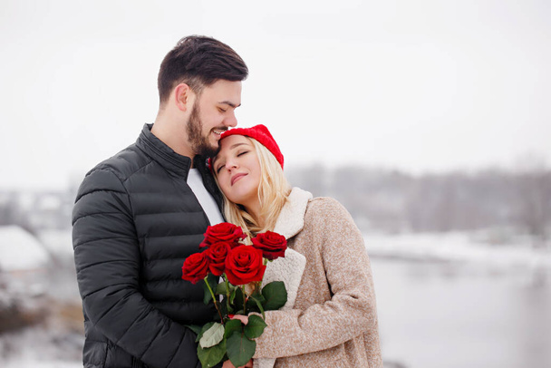 Jovem bonito cara dando uma menina um buquê de rosas no dia dos namorados - Foto, Imagem
