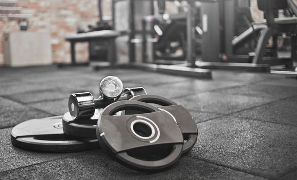 Barbell, dumbbells lie on the floor against the background of the gym. Free weight training. Functional powerful training - Photo, Image
