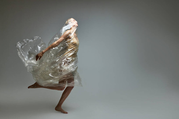 side view on female in a plastic bag, breaking free from plastic trash - Foto, Imagem