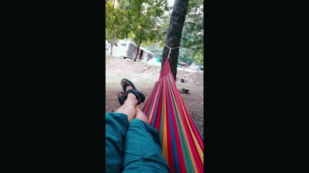 Ноги молодого человека, лежащего на гамаке размахивая - Кадры, видео