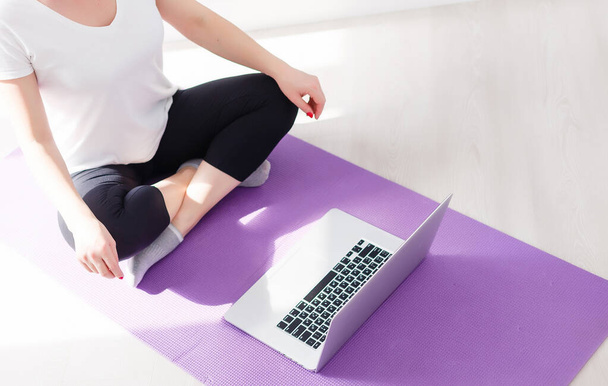 Hermosa mujer joven de formación en línea en casa en el ordenador portátil, espacio para copiar. Retrato de cuerpo entero. Yoga, pilates, hacer ejercicio - Foto, Imagen