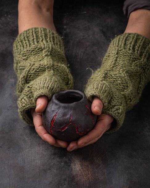 Ručně vyráběný šálek v ženských rukách, tmavá fotka - Fotografie, Obrázek