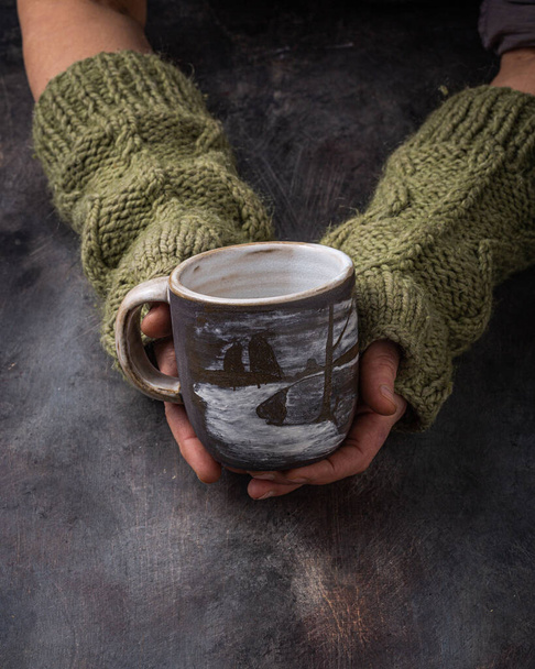 Hand made cup in female hands, dark photo - Foto, imagen