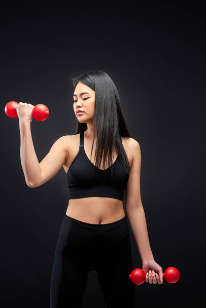 strong asian muscular woman exercising with dumbbells - Fotografie, Obrázek