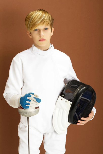 Boy fencer in white fencing costume with rapier - Фото, изображение