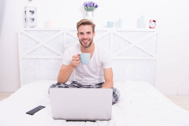 Happy man with laptop hold cup to stay hydrated being sick in bed at home with COVID-19, hydration - Foto, immagini