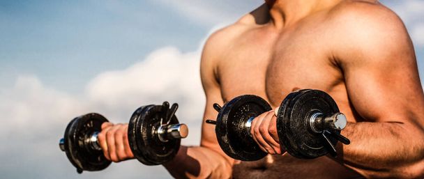 Strong bodybuilder. Muscles with dumbbell. Man training with dumbbells. Dumbbell. Muscular bodybuilder guys, exercises with dumbbells - Photo, Image
