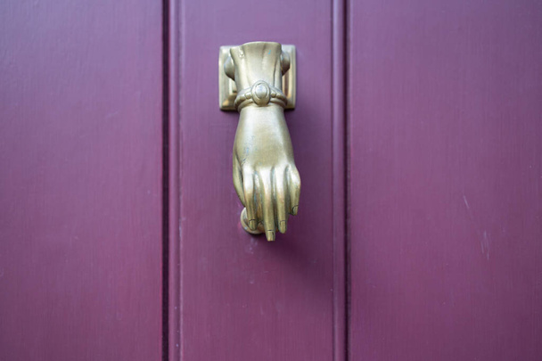 紫色のドアのドアのノッカーとして美しい手の彫刻 - 写真・画像