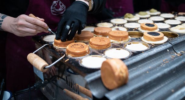 Ένας μάγειρας που φτιάχνει γιαπωνέζικες τούρτες σε μια λαϊκή αγορά. - Φωτογραφία, εικόνα