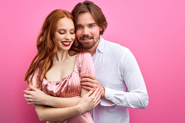 beautiful caucasian couple hugging, posing in studio on pink background - Fotografie, Obrázek