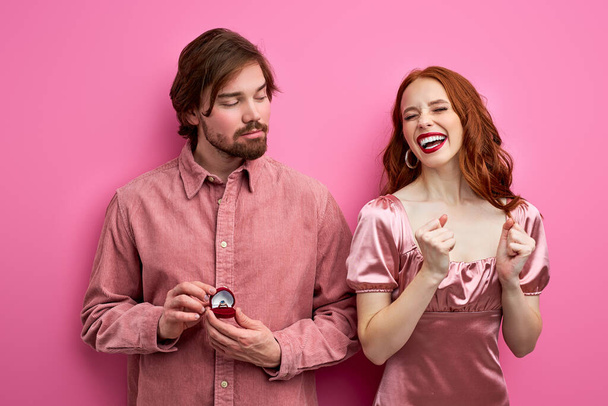 young couple two man woman in party outfit celebrating isolated on pink background - Foto, Imagem
