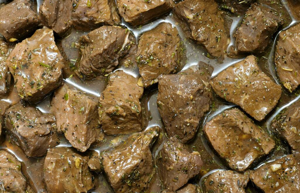 Gekleurde biefstukken van biefstuk in marinade met kruiden en specerijen. close-up volledige frame afbeelding. - Foto, afbeelding