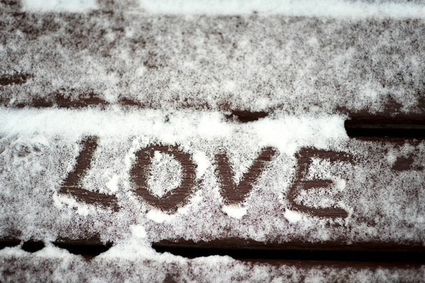 The inscription "love" in the snow. Valentine's day - Zdjęcie, obraz