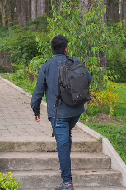 Fiatalember sétál az erdőben. A hátizsákjával, a mobiltelefonjával és a fotózással.. - Fotó, kép
