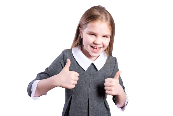 Schoolgirl shows thumbs up. Isolated on white background. High quality photo - Foto, imagen
