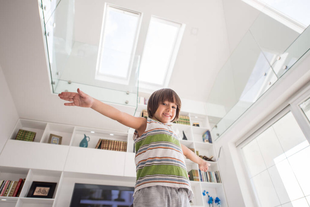 Happy kid at home with hands up - 写真・画像
