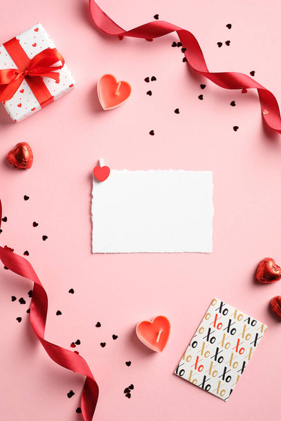 Valentines Day creative layout with blank paper card, gift box, red ribbon, confetti on pink background. Love, romance concept. - Zdjęcie, obraz