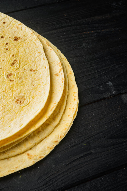 Corn tortilla flat, on black wooden table background  with copy space for text - Foto, immagini