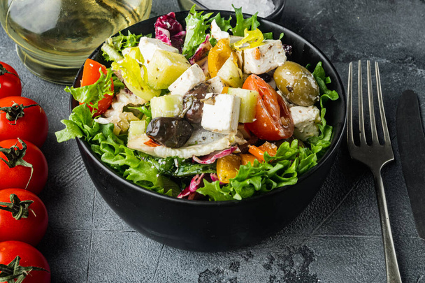 Salade grecque au poivre de tomate, olives et fromage feta, sur fond gris - Photo, image