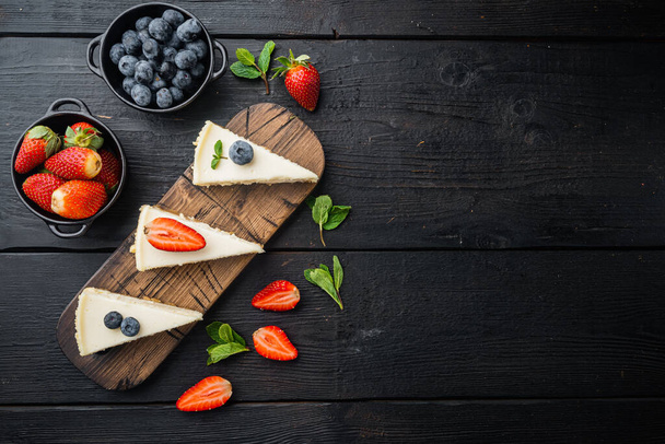 Tarta de queso de Nueva York o tarta de queso clásica con berrie fresca, sobre fondo de mesa de madera negro, vista superior plano con espacio de copia para el texto - Foto, Imagen