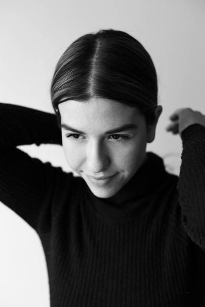 Black And White Portrait Of A Beauty. She is wearing a black sweater - Фото, изображение