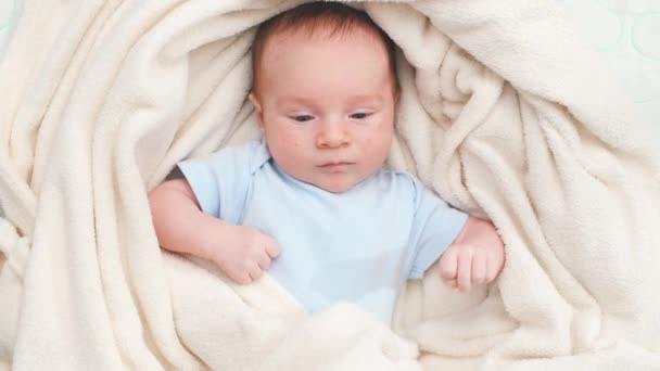 Vista superior de adorable bebé recién nacido cubierto de manta suave acostado en la cuna. - Imágenes, Vídeo