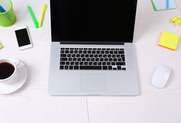 Office workplace with open laptop on wooden desk - Фото, зображення