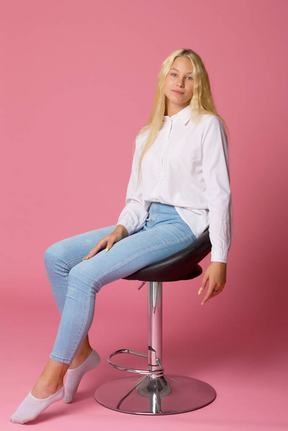 Cute Smiling Blonde Girl Sitting on High Chair in Studio - Foto, immagini
