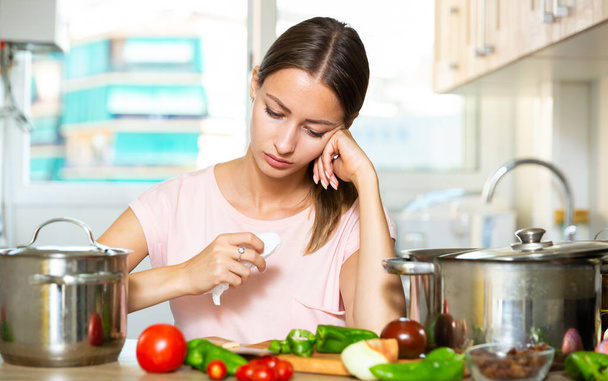 Unhappy woman trying to cook soup - Photo, image
