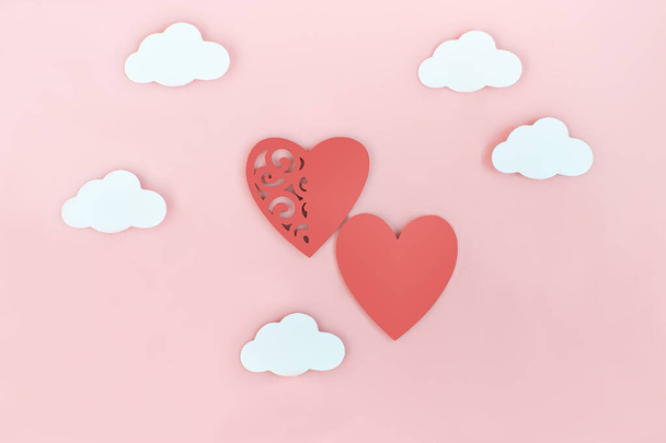 czerwone serca i chmury na różowym tle. Walentynki i koncepcja miłości. symbol ślubu. wsparcie i wspólnota. skopiować przestrzeń. widok z góry. - Zdjęcie, obraz