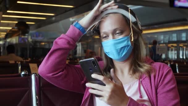Γυναίκα με ιατρική μάσκα και ασπίδα προσώπου στο αεροδρόμιο - Πλάνα, βίντεο