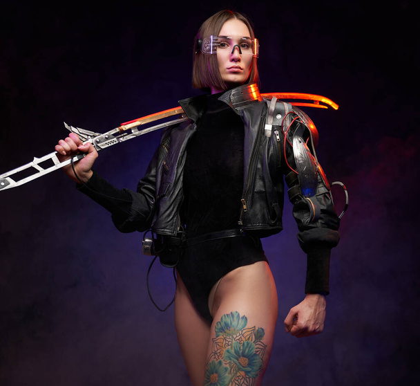 Portret van een vrouwelijke soldaat in cyberpunk stijl met gloeiend zwaard - Foto, afbeelding