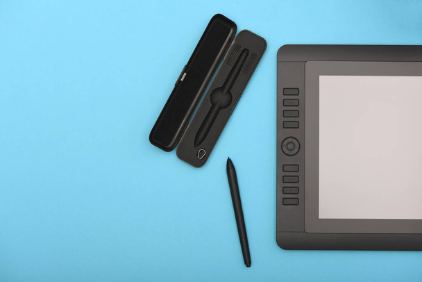 Monitor gráfico de lápiz y guante en la mesa de color azul. Tablet PC negro con pantalla en blanco. Foto de alta resolución. Profundidad total del campo. Concepto de entorno de trabajo - Foto, imagen