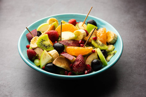 Fruit Chaat on intensiivinen intialainen ruokalaji, joka on valmistettu yhdistämällä jäähdytettyjä mehukkaita hedelmiä, kuten omenoita, banaaneja, appelsiineja, viinirypäleitä suolaan ja mietoja mausteita. - Valokuva, kuva