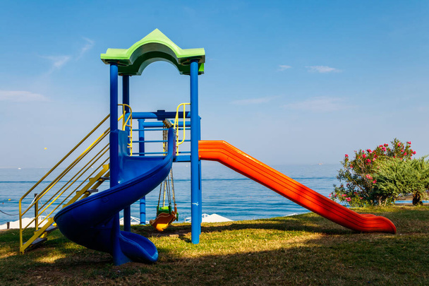 Современные детские площадки скользят по морскому пляжу - Фото, изображение