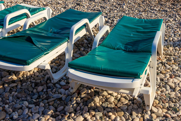 Chaise lounges on a pebble beach. Concept of rest, relaxation, holidays, resort - Photo, Image