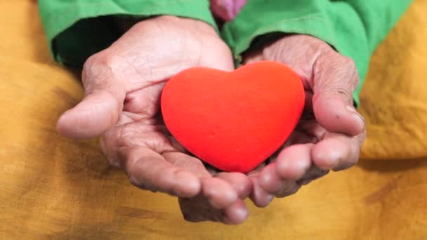  mujeres mayores sosteniendo el corazón rojo de cerca  - Imágenes, Vídeo