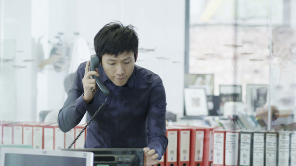 neformálně oblečený mladý profesionální muž na telefonu v moderní kancelářské - Záběry, video