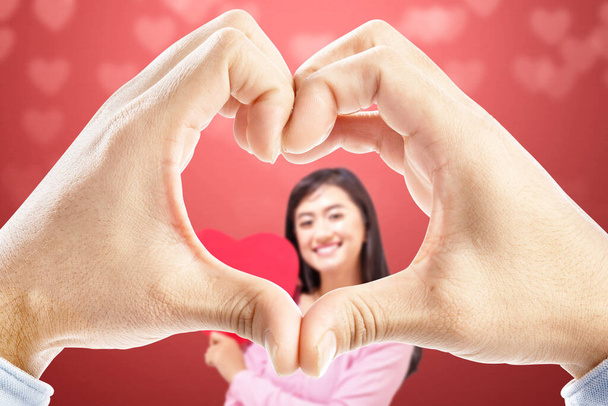 Мужские руки с формой сердца, на которых его подружка держит красное сердце. День Святого Валентина - Фото, изображение