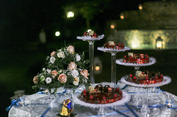 svatební dort s podbradky s červeným ovocem a figurkami. Kvalitní fotografie - Fotografie, Obrázek