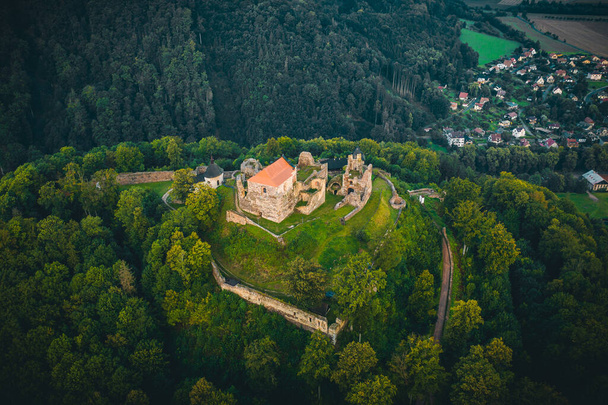 Rozległe ruiny zamku Potstejn leżą na zalesionym stożkowym wzgórzu na południowy wschód od miejscowości Potstejn we wschodnich Czechach i dominują w centralnej części Podorlicka.. - Zdjęcie, obraz