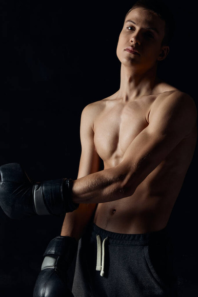 atleta en guantes de boxeo sobre fondo negro retrato primer plano - Foto, Imagen